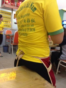 シンガポール式中華店でブラジルのユニフォームを切る店員さん