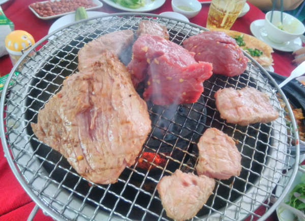 牛肉の塊を七輪の上で焼いている