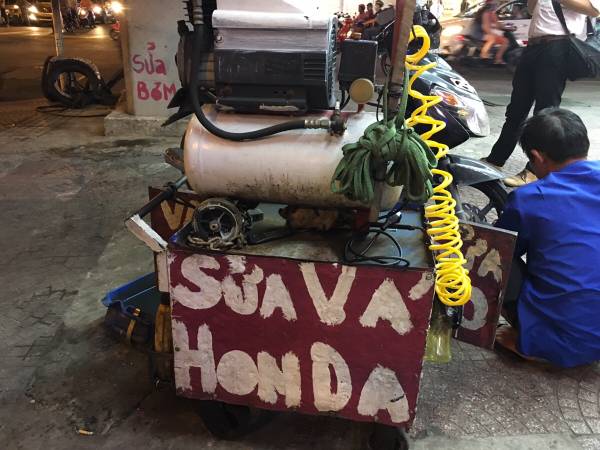 道路沿いで「sửa vá(パンク修理)」をしてもらっている様子