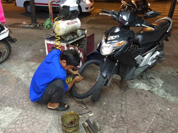 道路沿いで「sửa vá(パンク修理)」をしてもらっている様子(2)