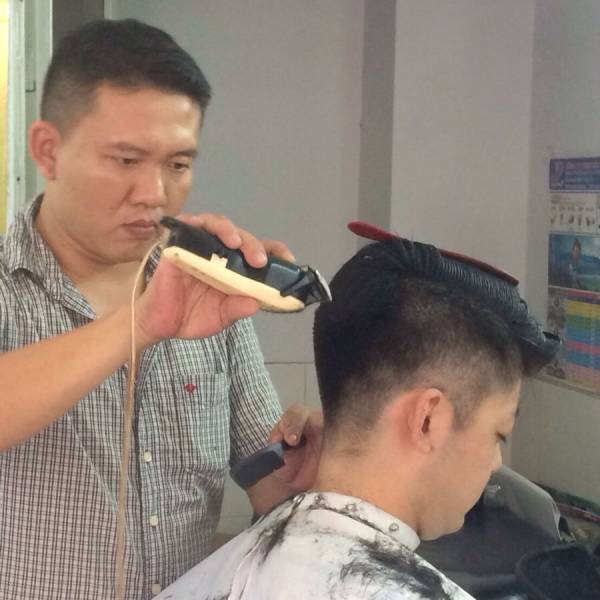 髪を刈られる金子