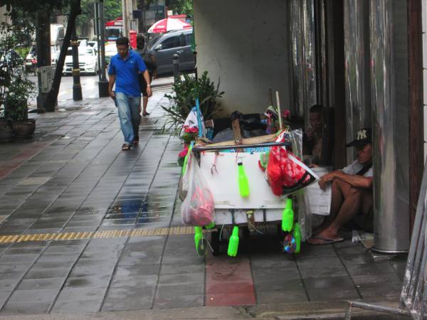建物の軒下で休憩する人たち