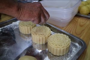 月餅作りの様子(焼く前の月餅の生地に爪楊枝で穴を空けている)