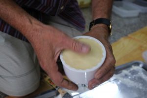 月餅作りの様子(生地を専用の容器につめて型どりしている①)