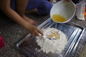 月餅作りの様子(スプーンで小麦粉と液体を混ぜている)